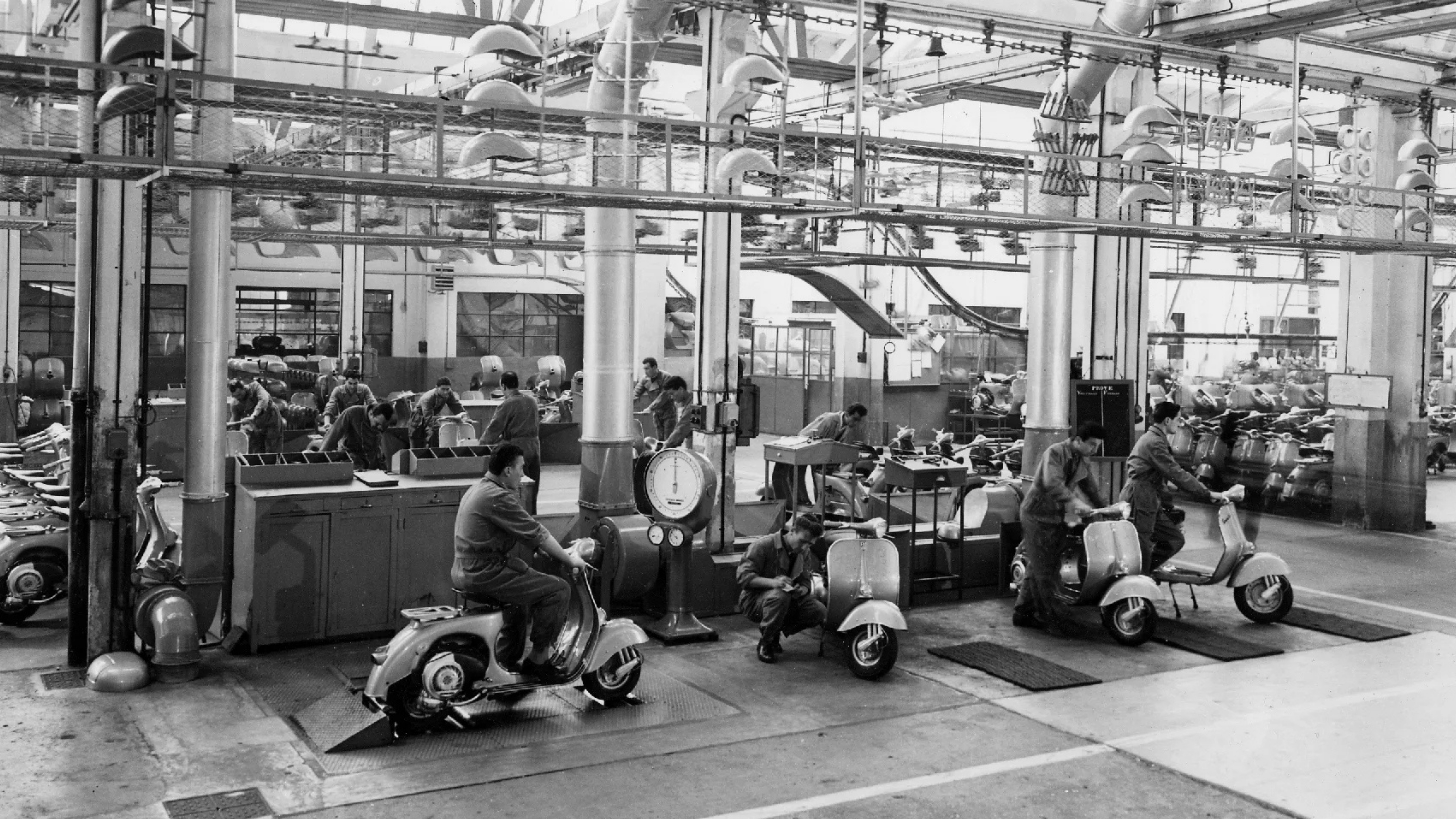 Piaggio fabrikasında Vespa üretim hattı, işçiler scooter üzerinde çalışırken